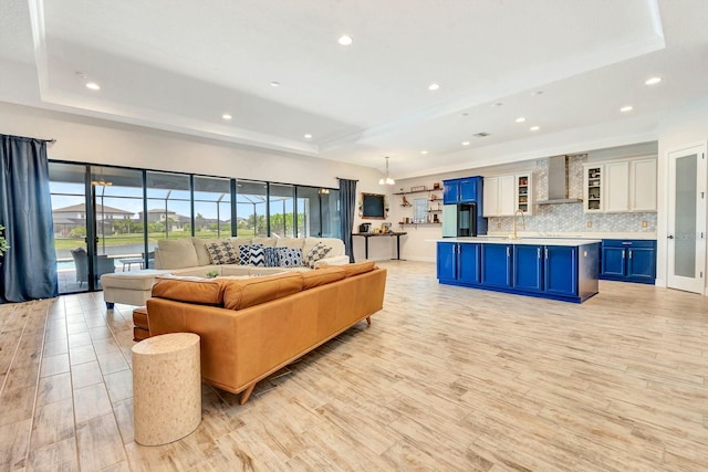 9215 Isabella Cir, Parrish, FL 34219 - living area with a tray ceiling, light wood-type flooring, and recessed lighting