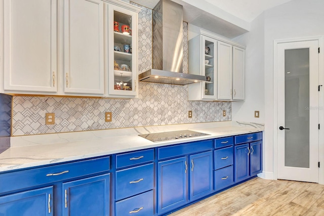 9215 Isabella Cir, Parrish, FL 34219 - kitchen featuring wall chimney range hood, black electric stovetop, blue cabinetry, tasteful backsplash, and light wood-style floors