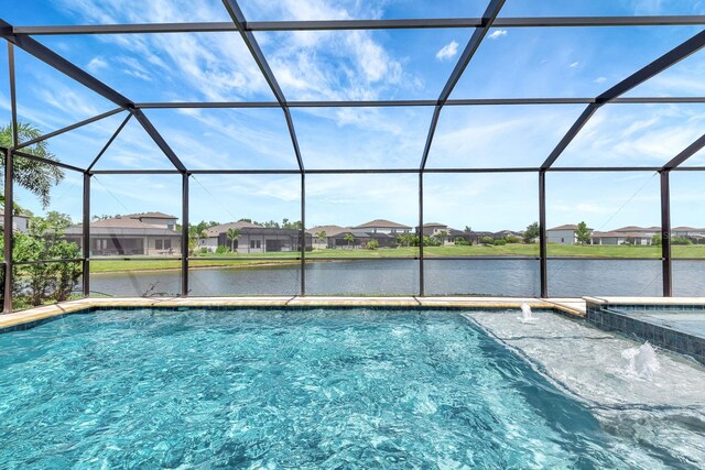 9215 Isabella Cir, Parrish, FL 34219 - view of swimming pool with a water view, a residential view, a pool with connected hot tub, and glass enclosure