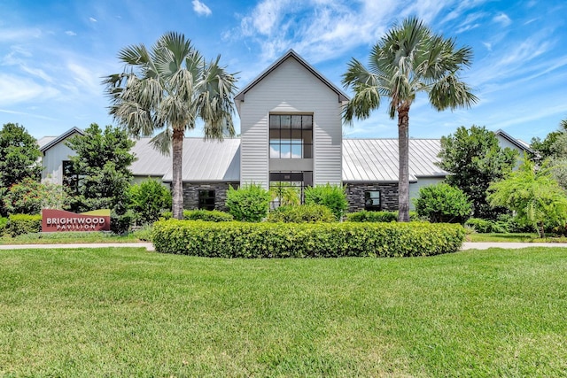 9215 Isabella Cir, Parrish, FL 34219 - view of front of house with stone siding, a standing seam roof, a front yard, and a metal roof