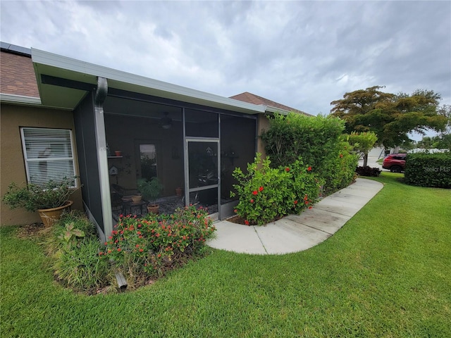 2819 47th St E, Palmetto, FL 34221 - view of property exterior with a sunroom, a lawn, and stucco siding