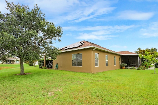 2819 47th St E, Palmetto, FL 34221 - view of side of home featuring roof mounted solar panels, stucco siding, a lawn, and a sunroom