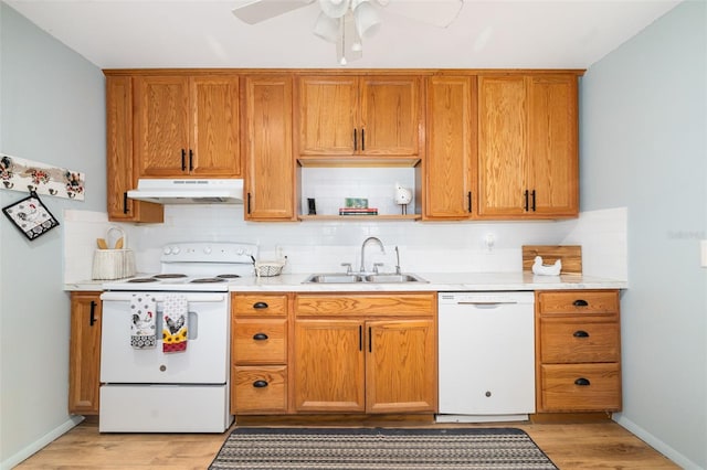 3020 51st Ave E, Bradenton, FL 34203 - kitchen featuring white appliances, under cabinet range hood, light wood-style flooring, and decorative backsplash