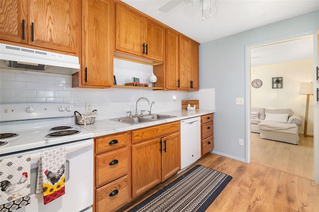 3020 51st Ave E, Bradenton, FL 34203 - kitchen featuring white appliances, under cabinet range hood, light wood-type flooring, tasteful backsplash, and light countertops