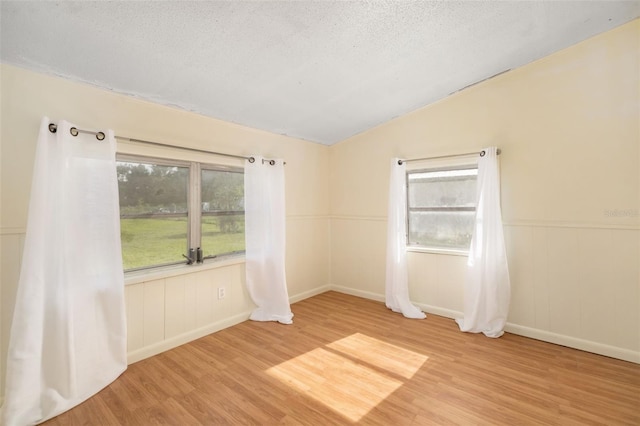 3020 51st Ave E, Bradenton, FL 34203 - spare room with light wood-style floors, vaulted ceiling, plenty of natural light, and a textured ceiling