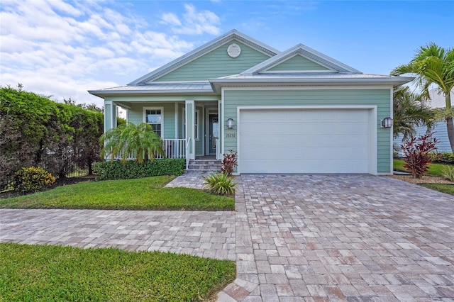 18050 Wooden Skiff Ct, Nokomis, FL 34275 - ranch-style house featuring decorative driveway, covered porch, an attached garage, and a front yard