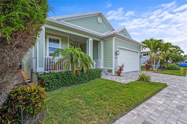 18050 Wooden Skiff Ct, Nokomis, FL 34275 - ranch-style home with an attached garage, covered porch, decorative driveway, and a front yard