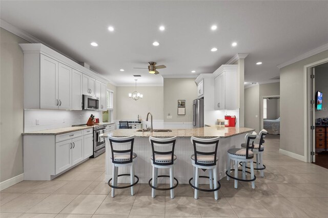 18050 Wooden Skiff Ct, Nokomis, FL 34275 - kitchen featuring appliances with stainless steel finishes, ornamental molding, recessed lighting, white cabinets, and a peninsula