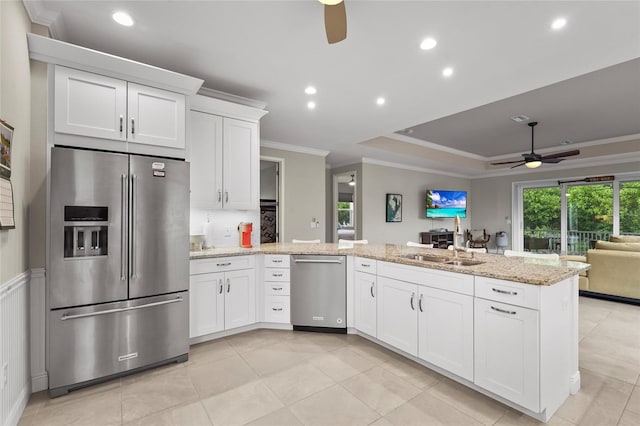 18050 Wooden Skiff Ct, Nokomis, FL 34275 - kitchen featuring stainless steel appliances, a ceiling fan, a peninsula, ornamental molding, and open floor plan
