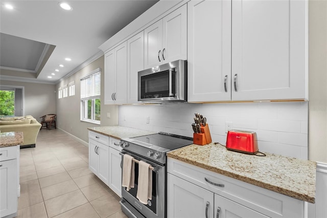 18050 Wooden Skiff Ct, Nokomis, FL 34275 - kitchen with stainless steel appliances, recessed lighting, crown molding, white cabinets, and open floor plan