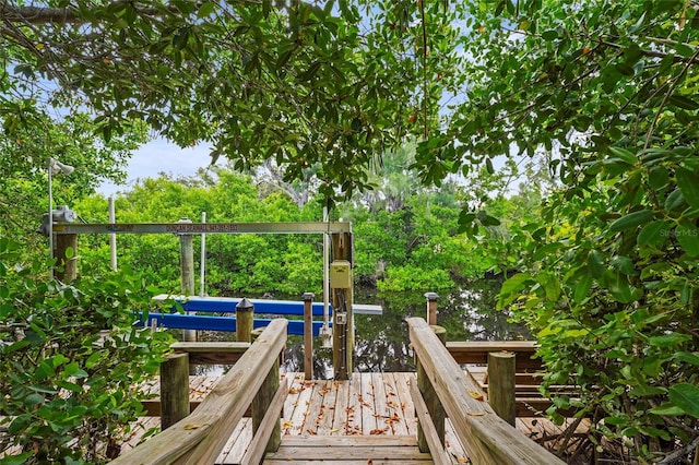 18050 Wooden Skiff Ct, Nokomis, FL 34275 - wooden deck with a dock, boat lift, and view of scattered trees