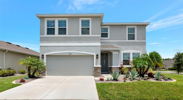 5134 Jackel Chase Dr, Wimauma, FL 33598 - view of front of home with stone siding, an attached garage, concrete driveway, stucco siding, and a front yard