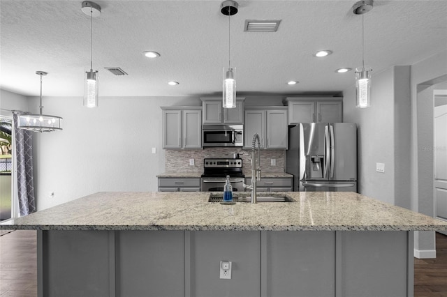 7036 Chatum Light Run, Bradenton, FL 34212 - kitchen featuring appliances with stainless steel finishes, gray cabinets, a textured ceiling, dark wood-style floors, and tasteful backsplash