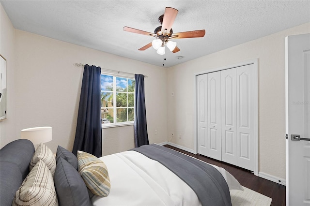 7036 Chatum Light Run, Bradenton, FL 34212 - bedroom featuring dark wood-type flooring, a closet, ceiling fan, and a textured ceiling