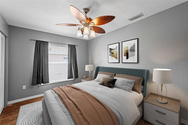 7036 Chatum Light Run, Bradenton, FL 34212 - bedroom featuring dark wood-type flooring, ceiling fan, a textured ceiling, and a textured wall