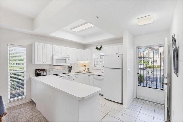 8335 Glenrose Way Unit 1513, Sarasota, FL 34238 - kitchen with white appliances, a peninsula, white cabinets, and plenty of natural light