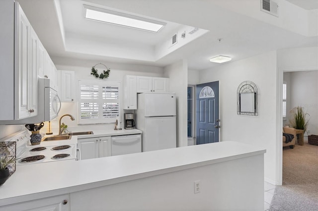 8335 Glenrose Way Unit 1513, Sarasota, FL 34238 - kitchen featuring white appliances, light countertops, a raised ceiling, and a peninsula