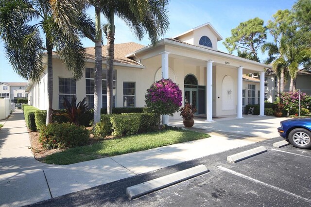 8335 Glenrose Way Unit 1513, Sarasota, FL 34238 - view of front of house featuring stucco siding, uncovered parking, and covered porch