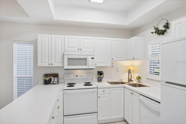 8335 Glenrose Way Unit 1513, Sarasota, FL 34238 - kitchen featuring white appliances, a tray ceiling, and white cabinets