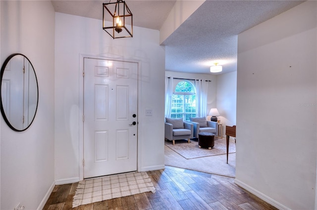 4204 Malickson Dr, Parrish, FL 34219 - entrance foyer with wood finished floors, a chandelier, and a textured ceiling