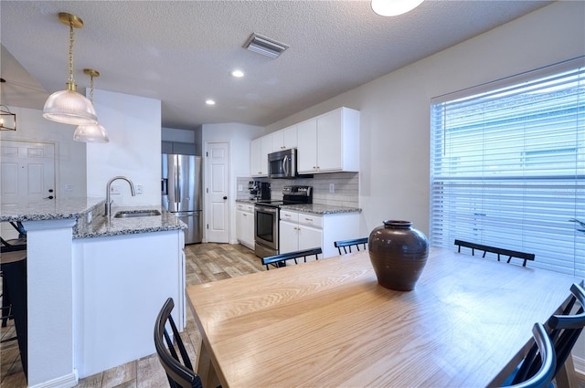 4204 Malickson Dr, Parrish, FL 34219 - dining area featuring light wood-type flooring, a textured ceiling, and recessed lighting