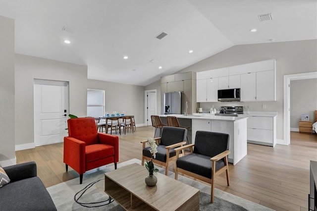 2703 Carmelia St, North Port, FL 34288 - living room with vaulted ceiling, light wood-style flooring, and recessed lighting