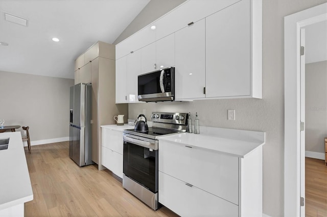 2703 Carmelia St, North Port, FL 34288 - kitchen featuring stainless steel appliances, light countertops, light wood finished floors, white cabinets, and recessed lighting
