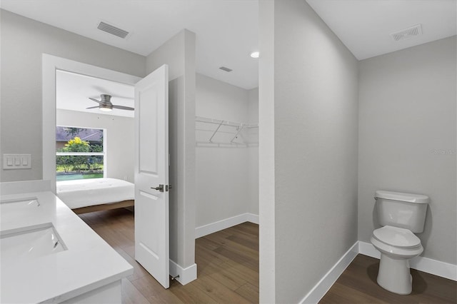 2703 Carmelia St, North Port, FL 34288 - full bathroom with double vanity, wood finished floors, ceiling fan, and a walk in closet