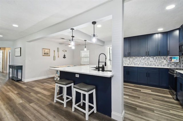 303 45th St W, Bradenton, FL 34209 - kitchen with blue cabinets, a breakfast bar area, a ceiling fan, backsplash, and recessed lighting