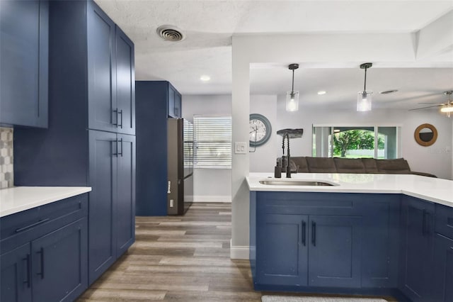 303 45th St W, Bradenton, FL 34209 - kitchen with blue cabinetry, plenty of natural light, wood finished floors, light countertops, and recessed lighting