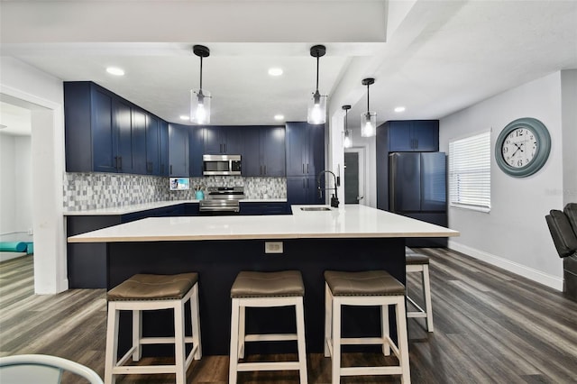 303 45th St W, Bradenton, FL 34209 - kitchen with stainless steel appliances, blue cabinets, dark wood finished floors, a breakfast bar, and recessed lighting