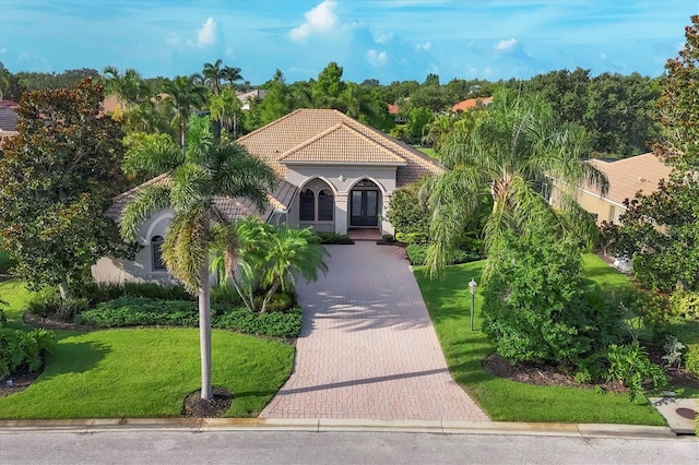 13818 Milan Ter, Lakewood Ranch, FL 34202 - mediterranean / spanish house featuring french doors, a tile roof, a front lawn, and stucco siding