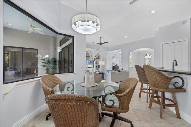 13818 Milan Ter, Lakewood Ranch, FL 34202 - dining space with a ceiling fan, arched walkways, light tile patterned flooring, crown molding, and recessed lighting