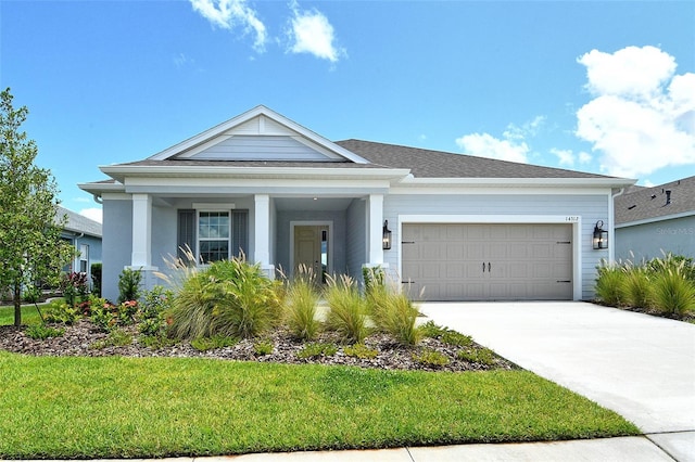 14312 Skipping Stone Loop, Parrish, FL 34219 - view of front of home with a garage, concrete driveway, a front yard, and covered porch