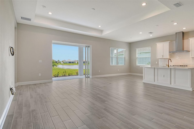 14312 Skipping Stone Loop, Parrish, FL 34219 - unfurnished living room featuring a tray ceiling, healthy amount of natural light, light wood finished floors, and recessed lighting