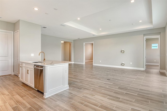 14312 Skipping Stone Loop, Parrish, FL 34219 - kitchen featuring stainless steel dishwasher, open floor plan, light wood-type flooring, white cabinets, and a tray ceiling