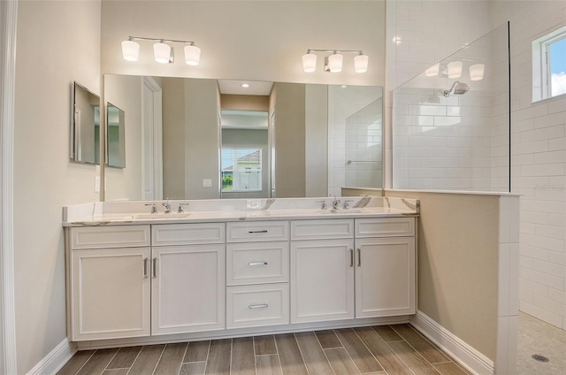 14312 Skipping Stone Loop, Parrish, FL 34219 - bathroom featuring a walk in shower, double vanity, and wood finish floors