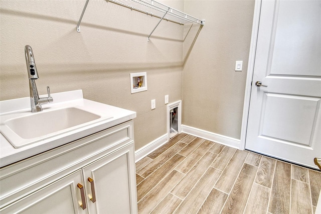 14312 Skipping Stone Loop, Parrish, FL 34219 - washroom with washer hookup, light wood-style flooring, and cabinet space