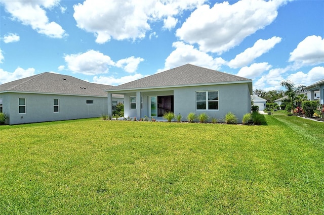 14312 Skipping Stone Loop, Parrish, FL 34219 - back of property with a lawn, stucco siding, and roof with shingles