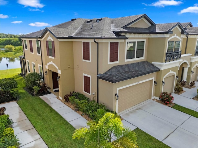 5174 78th St Cir E, Bradenton, FL 34203 - townhome / multi-family property featuring an attached garage, stucco siding, a water view, driveway, and roof with shingles