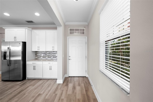 5174 78th St Cir E, Bradenton, FL 34203 - kitchen featuring stainless steel fridge with ice dispenser, crown molding, light wood finished floors, decorative backsplash, and white cabinets