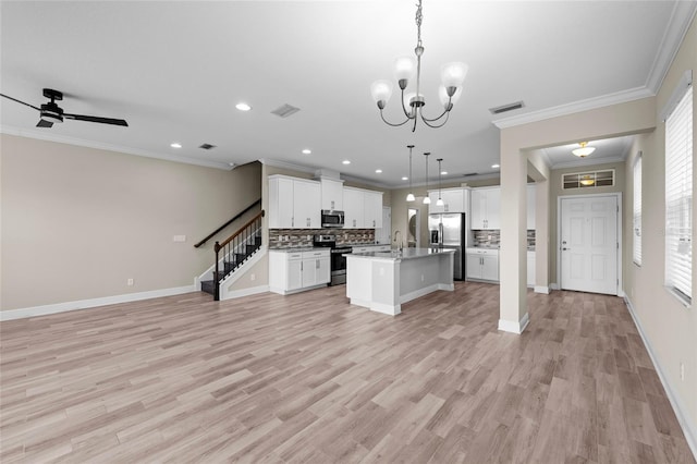 5174 78th St Cir E, Bradenton, FL 34203 - kitchen with stainless steel appliances, open floor plan, decorative backsplash, a center island with sink, and crown molding