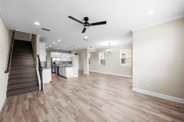 5174 78th St Cir E, Bradenton, FL 34203 - unfurnished living room with crown molding, a ceiling fan, recessed lighting, stairs, and a chandelier