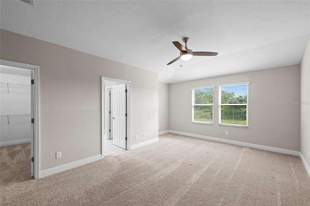 5174 78th St Cir E, Bradenton, FL 34203 - unfurnished bedroom with light carpet, a walk in closet, and a ceiling fan