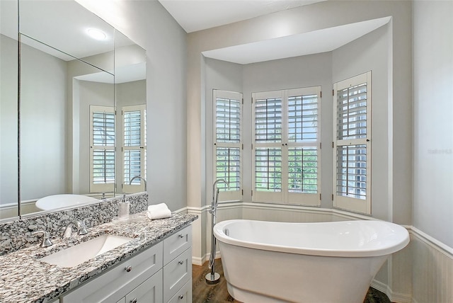 7868 Chick Evans Pl, Sarasota, FL 34240 - full bath featuring vanity, plenty of natural light, a soaking tub, and wood finished floors