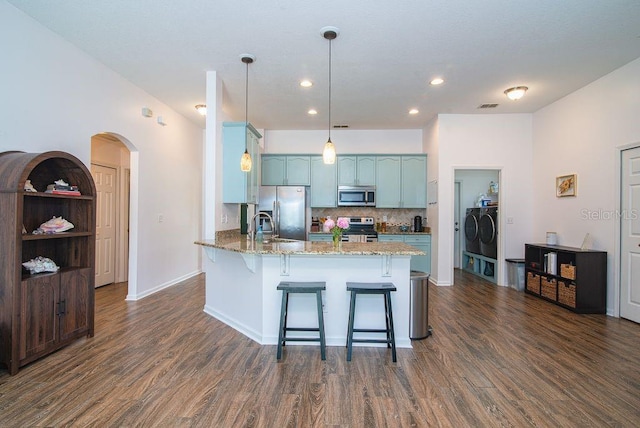 572 Sparrow Branch Cir, Saint Johns, FL 32259 - kitchen with appliances with stainless steel finishes, a peninsula, dark wood-style floors, independent washer and dryer, and recessed lighting