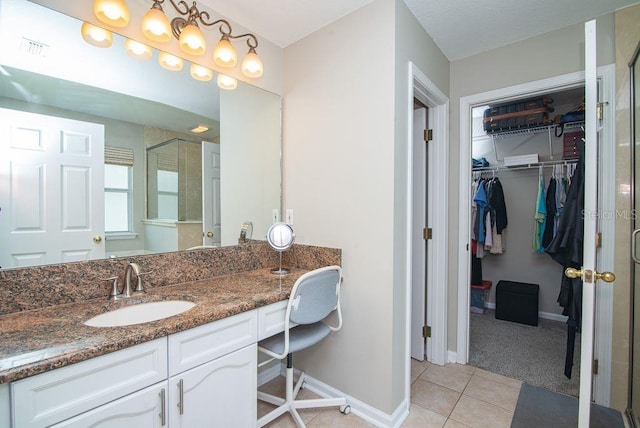 572 Sparrow Branch Cir, Saint Johns, FL 32259 - bathroom with vanity, tile patterned floors, a spacious closet, and a shower