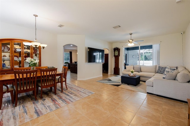 5242 Abdella Ln, North Port, FL 34291 - dining space featuring arched walkways, a chandelier, a ceiling fan, and light tile patterned floors