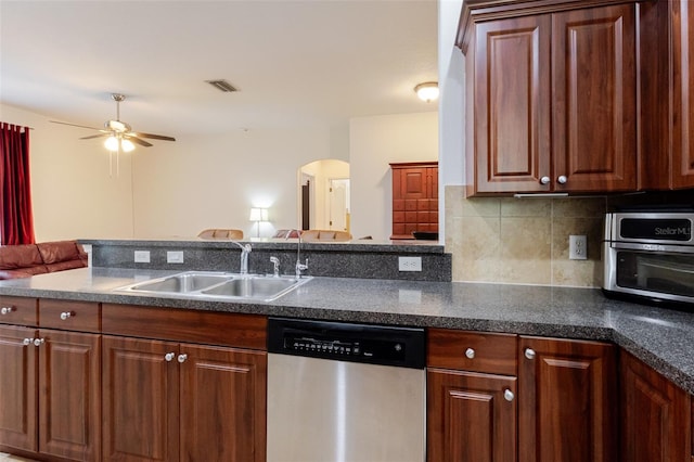 5242 Abdella Ln, North Port, FL 34291 - kitchen with dishwasher, arched walkways, a ceiling fan, backsplash, and dark countertops