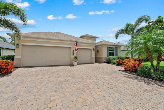 12215 Goldenrod Ave, Bradenton, FL 34212 - view of front of home featuring stucco siding, an attached garage, and decorative driveway